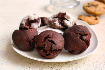 Plate with tasty brownie cookies on light grunge background