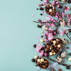 Festive Easter background, chocolate sweets, quail eggs and blooming almond
