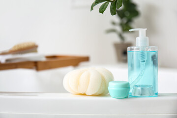 Fototapeta na wymiar Sponge and cosmetic products on bathtub