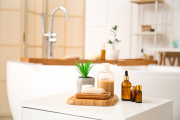 Fototapeta na wymiar Soap, plant and cosmetic products on table in bathroom