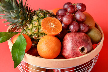 Basket with fresh juicy fruits on color background