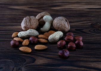 Appetizing and useful different nuts on a wooden background
