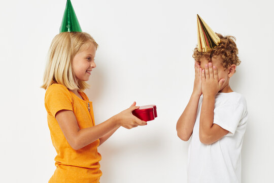 Cheerful boy with girl with hats gift birthday holiday