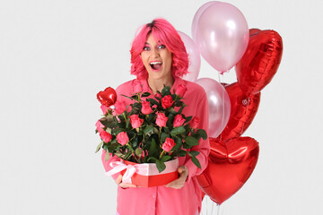 Surprised woman with bright hair, bouquet of flowers and air balloons on light background. Valentine's Day celebration