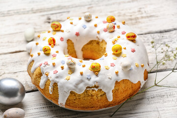 Plate with tasty Easter cake and eggs on white wooden background