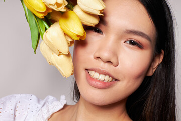 Obraz na płótnie Canvas Charming young Asian woman flowers spring posing isolated background unaltered
