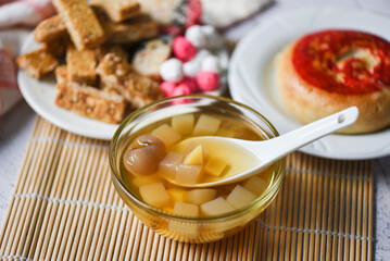 Chinese desserts chinese pastry bean cake, Snack mix nuts candies sweets sugar nuts sesame seeds coated beans puffed rice, milk pudding fruit salad longan juice bowl in chinese new year festival food