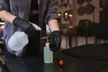 Close up of women's hands disinfects tools before tattooing