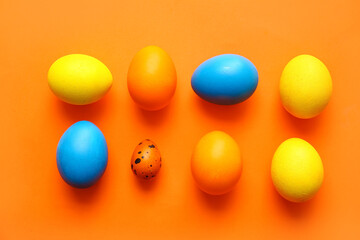 Different painted Easter eggs on color background