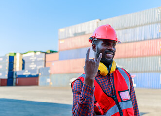 Portrait of a smiling container worker or a cheerful foreman wearing a hard hat. Red Blurred Box Container Background concept of success and moving industrial products logistics import-export