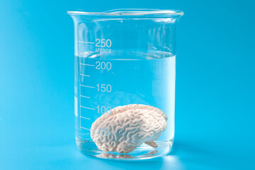Conscious and subconscious mind, brains neural chemistry and research into the human consciousness concept with brain in jar isolated on blue background