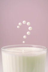 Milk drips into a transparent faceted glass.