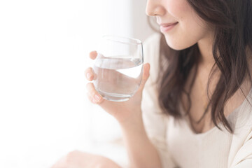 グラスに入った水を飲む日本人女性 - obrazy, fototapety, plakaty