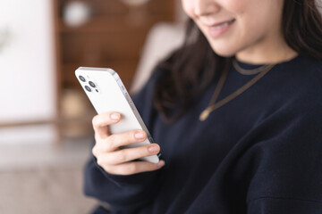 ソファーでスマホを持つ女性