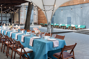 Flower table decorations for holidays and wedding dinner. Table set for holiday, event, party or wedding reception in outdoor restaurant.