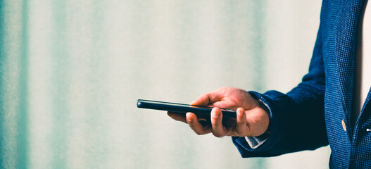 businessman holds a smartphone in his hand, the concept of online communication