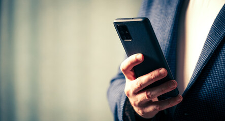 businessman holds a smartphone in his hand, the concept of online communication