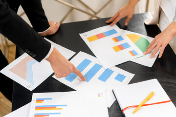 Cropped view of the man and woman discussing documents while standing at the table and looking...