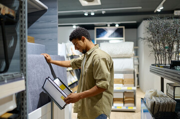 Young man reading catalog in furniture shop