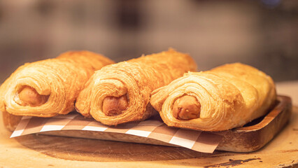Croissant stuffed with hot dogs Three pieces are placed in a plate.