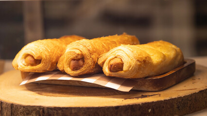 Croissant stuffed with hot dogs Three pieces are placed in a plate.