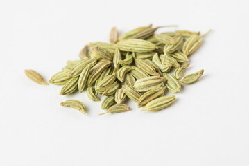 Macro photo of green fennel seeds on a white background. Fennel is a traditional Indian aromatic seasoning and ingredient of Ayurvedic food