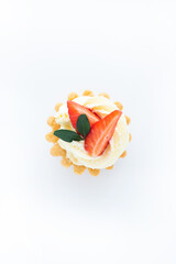 Tartlets with cream and fresh strawberry on white background, top view