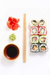 Set of different sushi with chopsticks on white background, top view flat lay