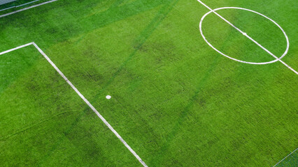 Obraz premium The futsal court is lined with green artificial grass and has white demarcation lines and dots.