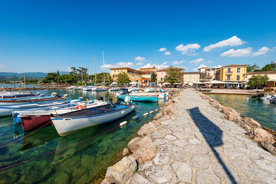 Small port of Cisano village with small boats moored. Tourist resort on the coast of Lake Garda (Lago di Garda). Bardolino municipality, Verona province, Veneto, Italy, southern Europe. 