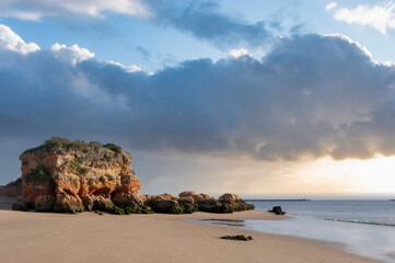 Solitary rock on the beach Praia Grande in Ferragudo on the Algarve