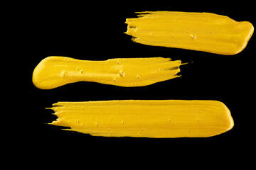 Acrylic gold paint brush on a black background