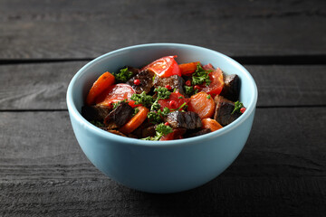 Plate with beef with vegetables on wooden background