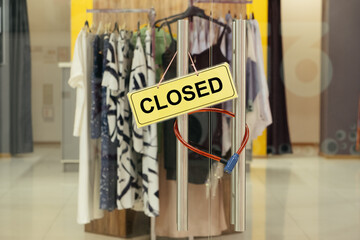 "Closed" sign on the door of a clothing store.