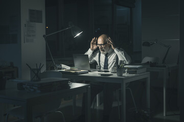 Exhausted angry businessman working overtime