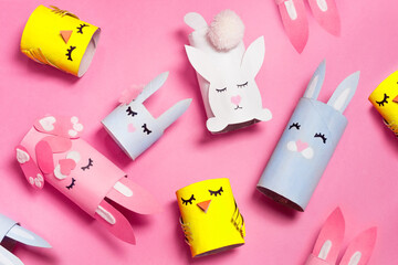 Easter bunny craft from paper tube flat lay. Kids DIY activities. Handmade cute toy rabbits and chicken. Reuse concept