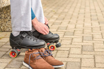 Man putting on roller skates. Changing casual shoes to roller skates before ride and training during summer leisure and recreation.