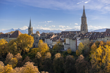 Bern im Herbst – Blick auf die Berner Altstadt und das Berner Münster. Am Horizont sieht man die Berge vom Berner Oberland. - 484120861