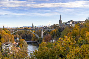 Bern im Herbst – Blick auf den Fluss Aare, die Kornhausbrücke und das Münster. Am Horizont sieht man die Berge vom Berner Oberland. - 484120864