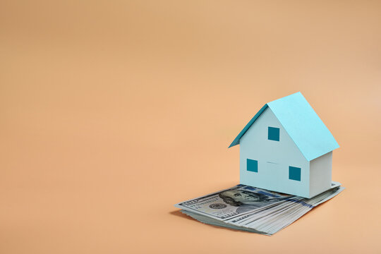 One hundred dollar bills and model house with copy space, commercial real estate and investment concept