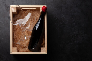 Red wine and glasses in wooden box