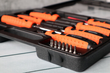 A set of screwdrivers with various attachments in a black suitcase for storage.