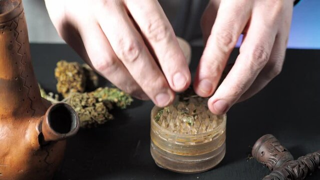 one of a series of smoking medical cannabis. grinding marijuana in a grinder. in the frame male hands bong smoking pipe grinder medical cannabis buds. 4k