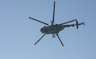 The military helicopter against the blue sky