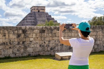 Tourist taking a photo at the Mayan pyramid temple of Kukulkan in Chichen Itza, the famous feathered serpent god of the Mayas.