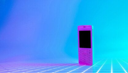 Retro cell phone vintage concept. White old mobile telephone in neon pink blue light. Retro wave....