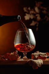 Brandy is poured from a bottle into a glass.