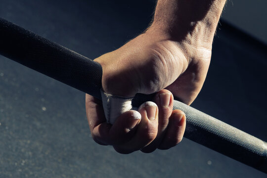 Close-up Of Man's Right Hand Gripping A Barbell With A Hook Grip