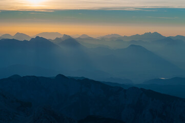 Layers of mountain ranges in Julian Alps at sunrise time in Slovenia viewed from the peak of Triglav