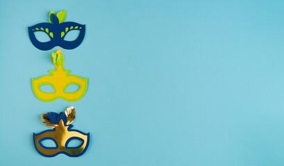 Three carnival masks on blue background. Copy space.
